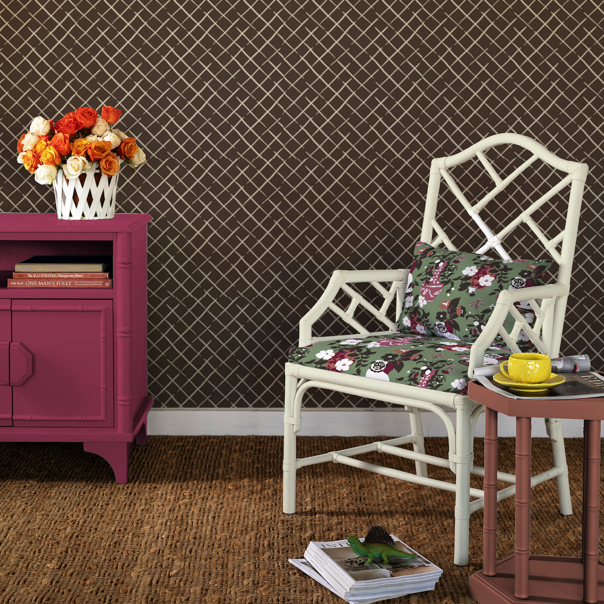 A room setting showing a wall adorned with unpasted wallpaper featuring a geometric lattice pattern, along with a chair with floral upholstery, a purple side table, and a decorative basket with flowers.