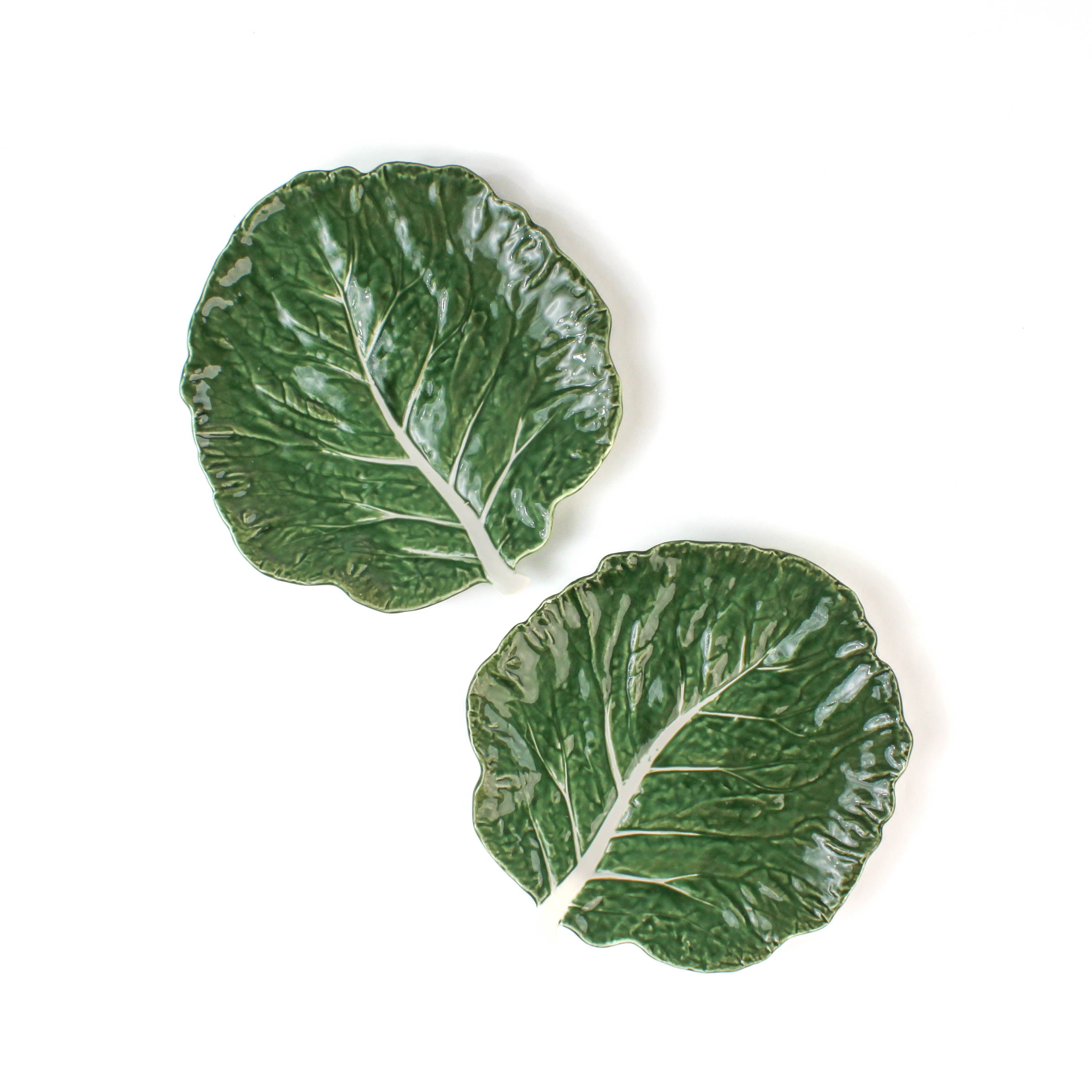a ceramic green cabbage leaf plate on a white background.