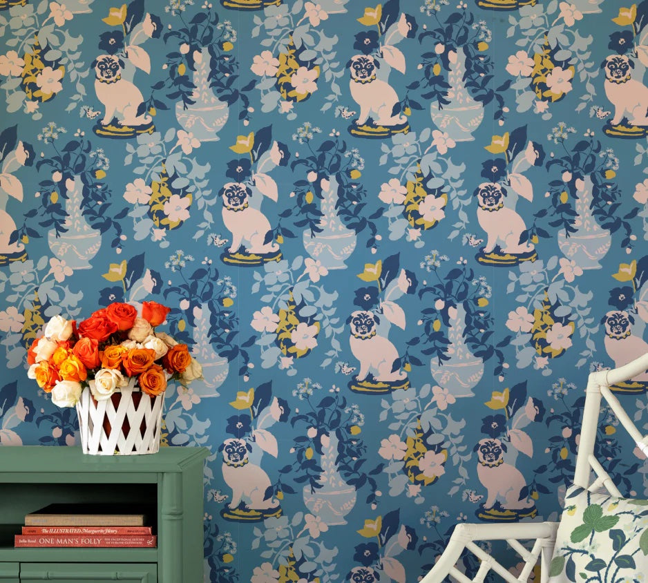 A green table against a wall of blue and white chinoiserie wallpaper with a pug motif.
