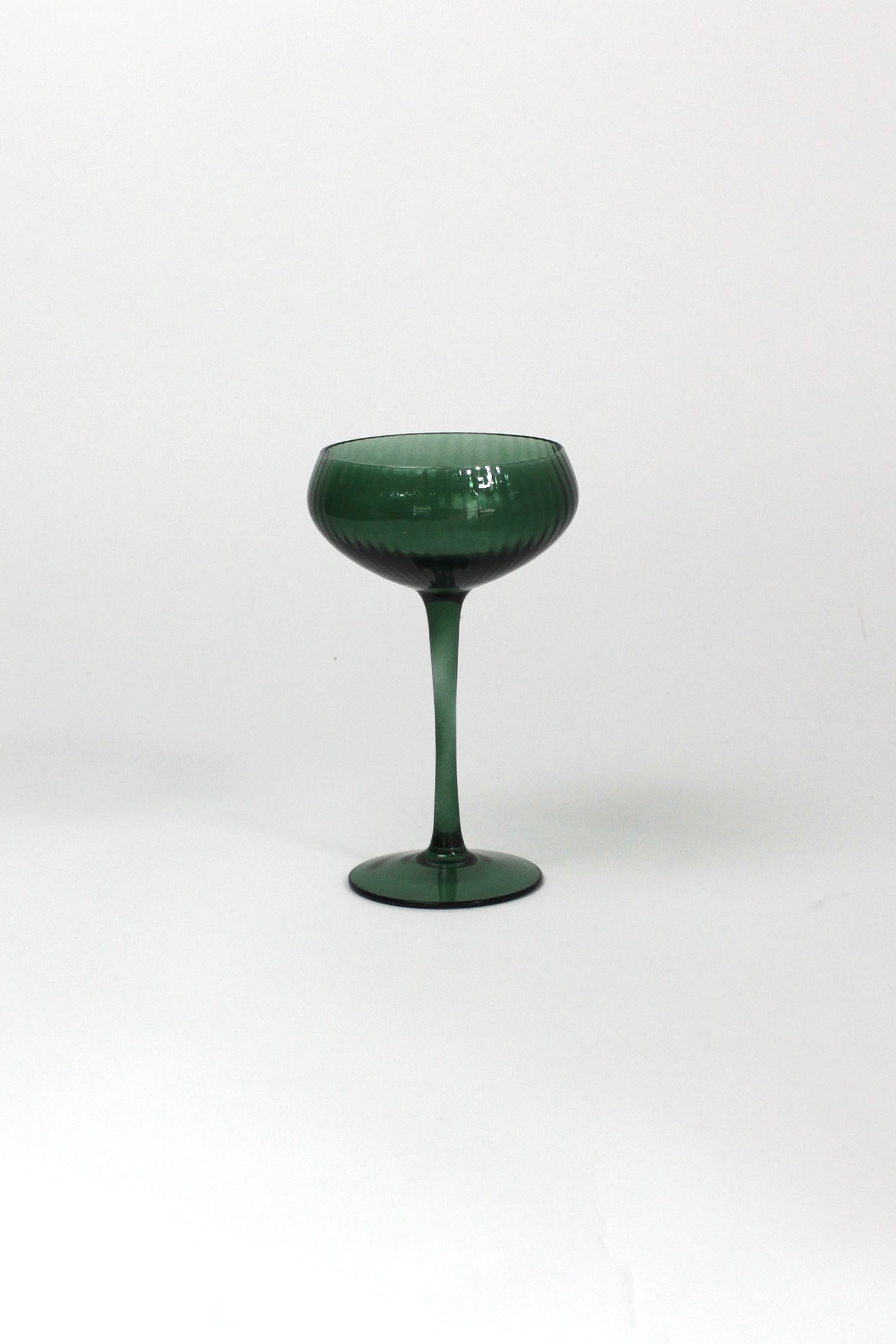 a green coupe glass on a white background from madcap cottage