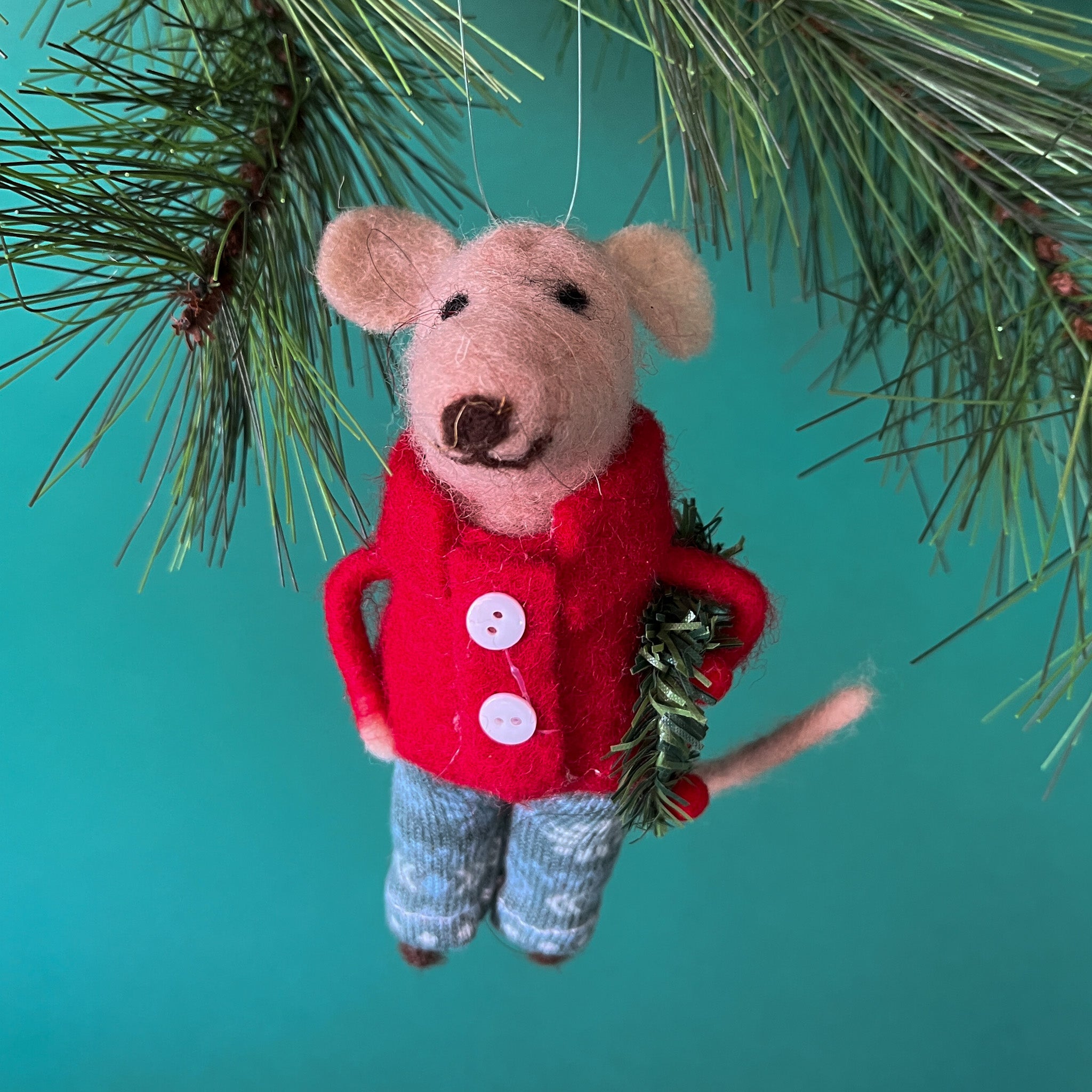 felt mouse ornament wearing a red jacket and patterned blue-green pants, holding a festive green wreath with red accents.