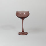 a pink coupe glass on a white background