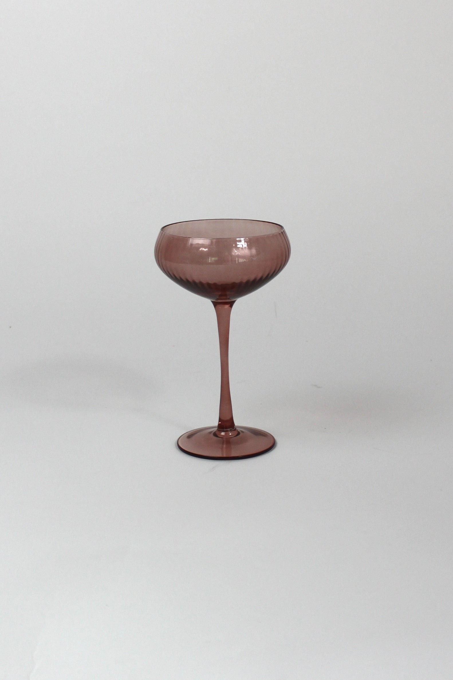 a pink coupe glass on a white background