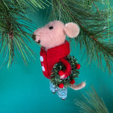 sied of a felt mouse ornament wearing a red jacket and patterned blue-green pants, holding a festive green wreath with red accents.