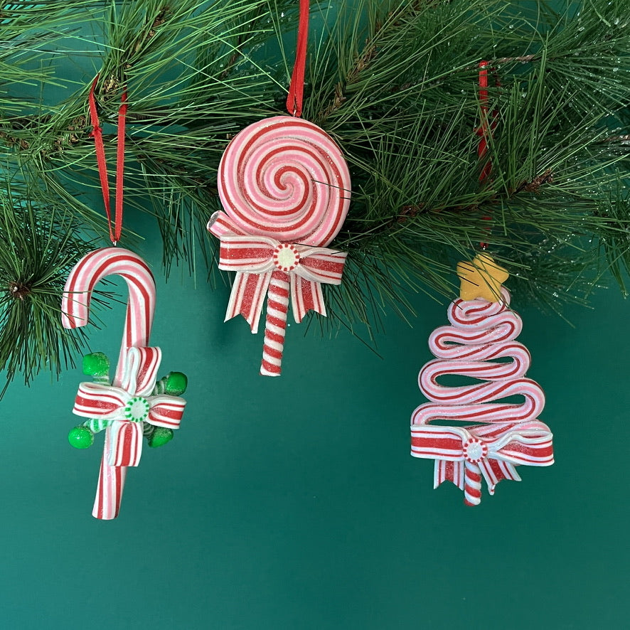 Set of three colorful candy-themed Christmas ornaments shaped like candy canes, lollipops, and Christmas trees