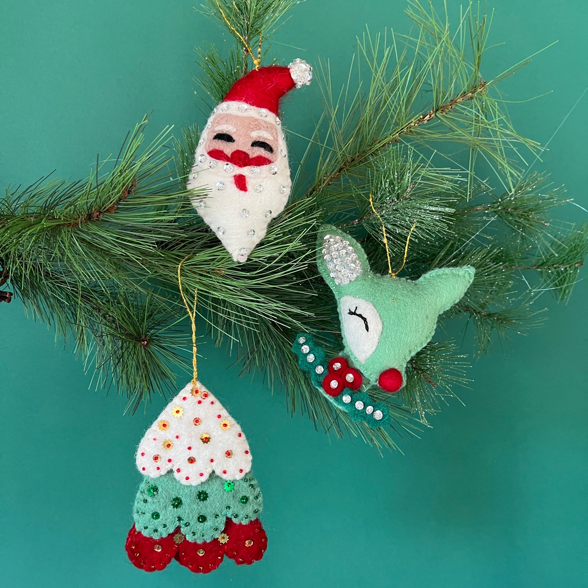 Handcrafted Holiday Icons Felt Christmas Ornaments featuring Santa, reindeer, and Christmas tree designs in festive red, green, and white colors.