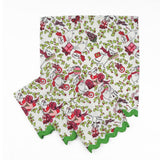 Set of White Christmas dinner napkins featuring festive mice, holly leaves, colorful gifts, and green scalloped trim.