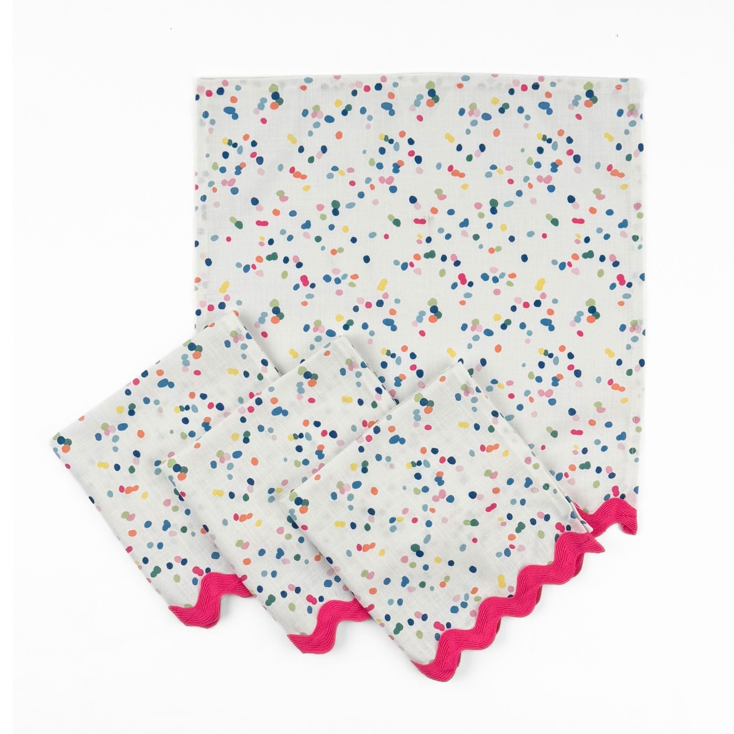 Set of White cloth dinner napkins featuring playful multicolor confetti dots and bright pink ric rac trim.
