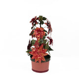 A large metal handpainted Christmas candle holder featuring red poinsettia flowers and green holly leaves with a pink base. 