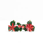 A metal christmas place card holder decorated with red poinsettia flowers and holly leaves 