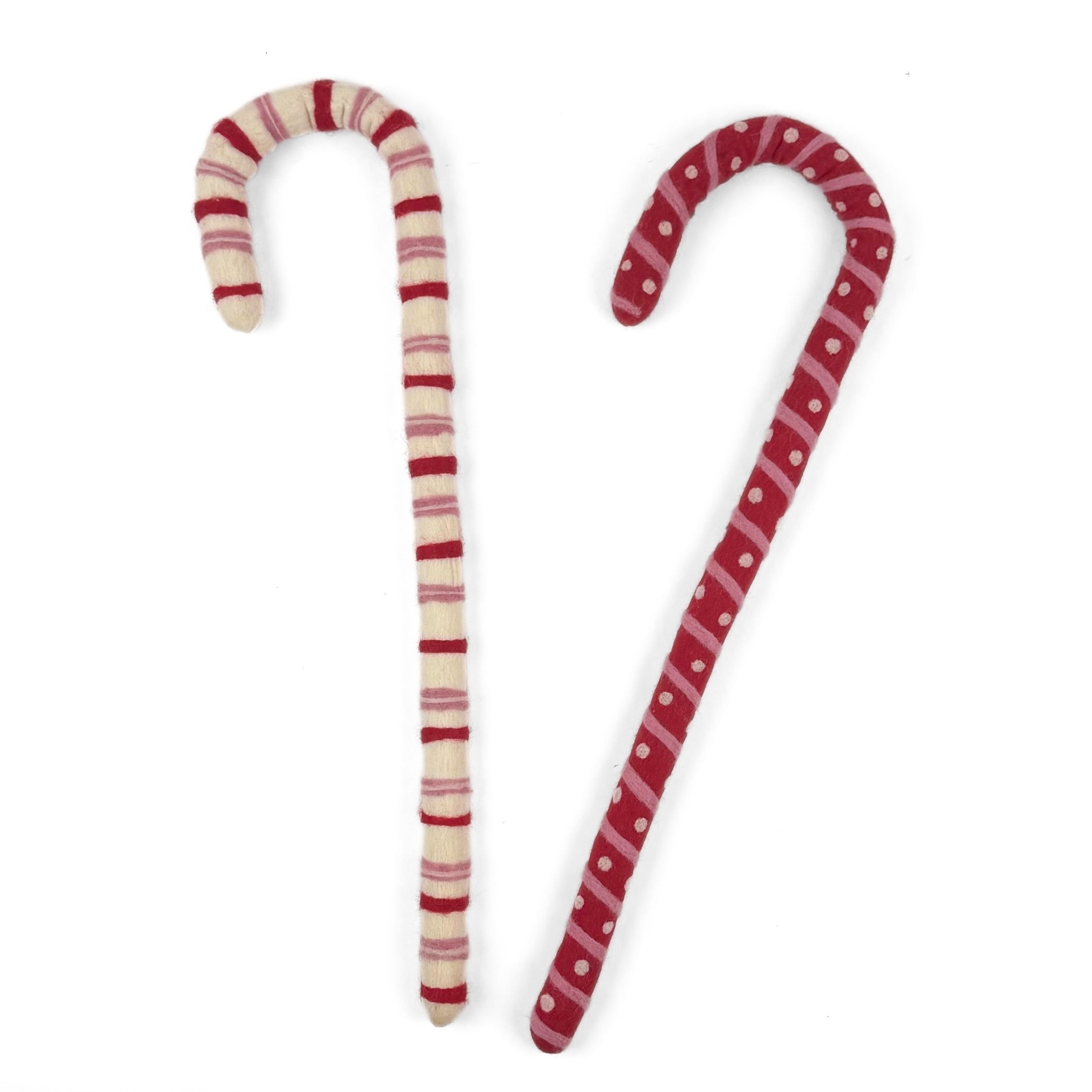 Large felt Christmas candy canes featuring festive red, pink, and cream stripes with playful patterns.