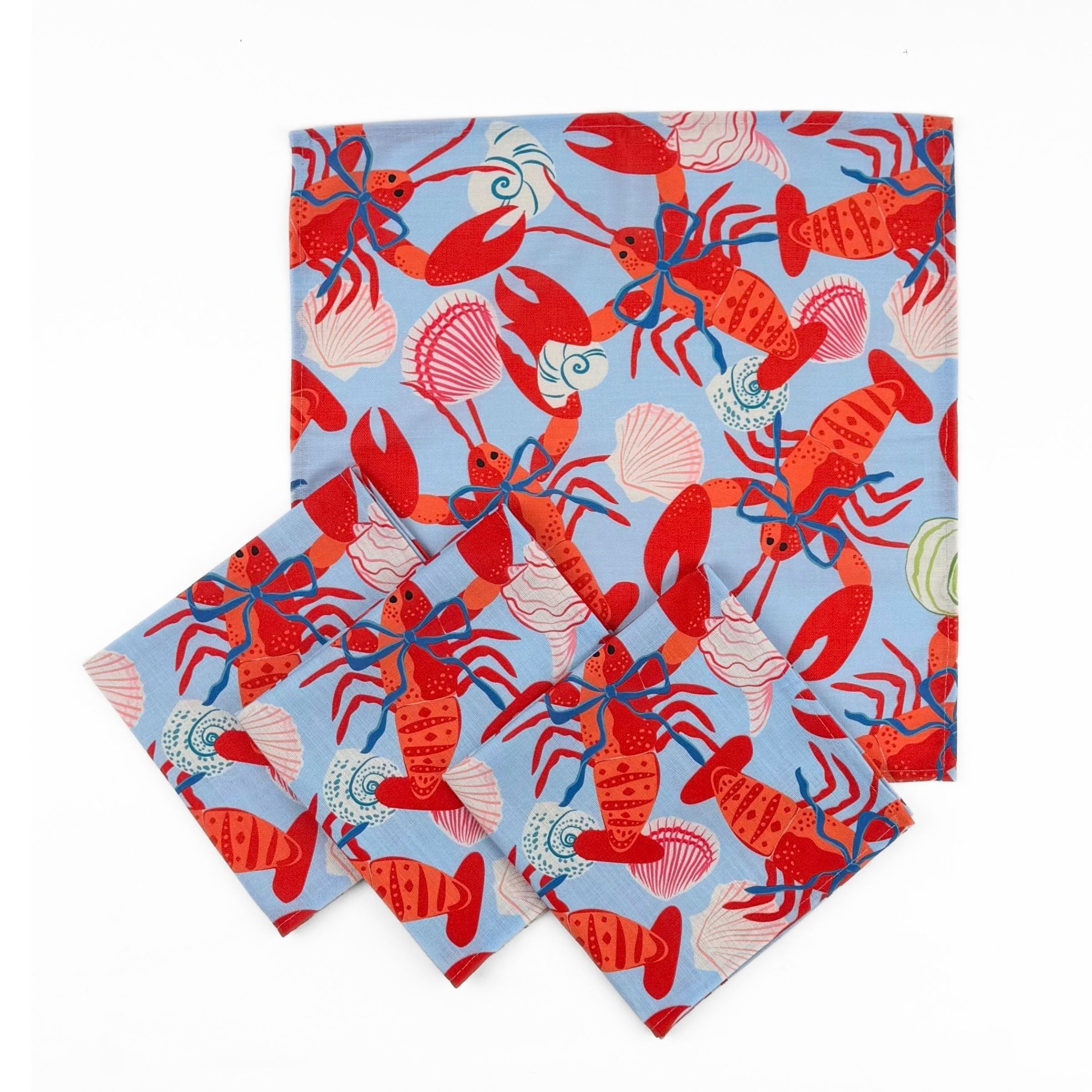 Set of Blue cloth dinner napkins featuring vibrant red lobsters, seashells, and playful coastal patterns for entertaining.