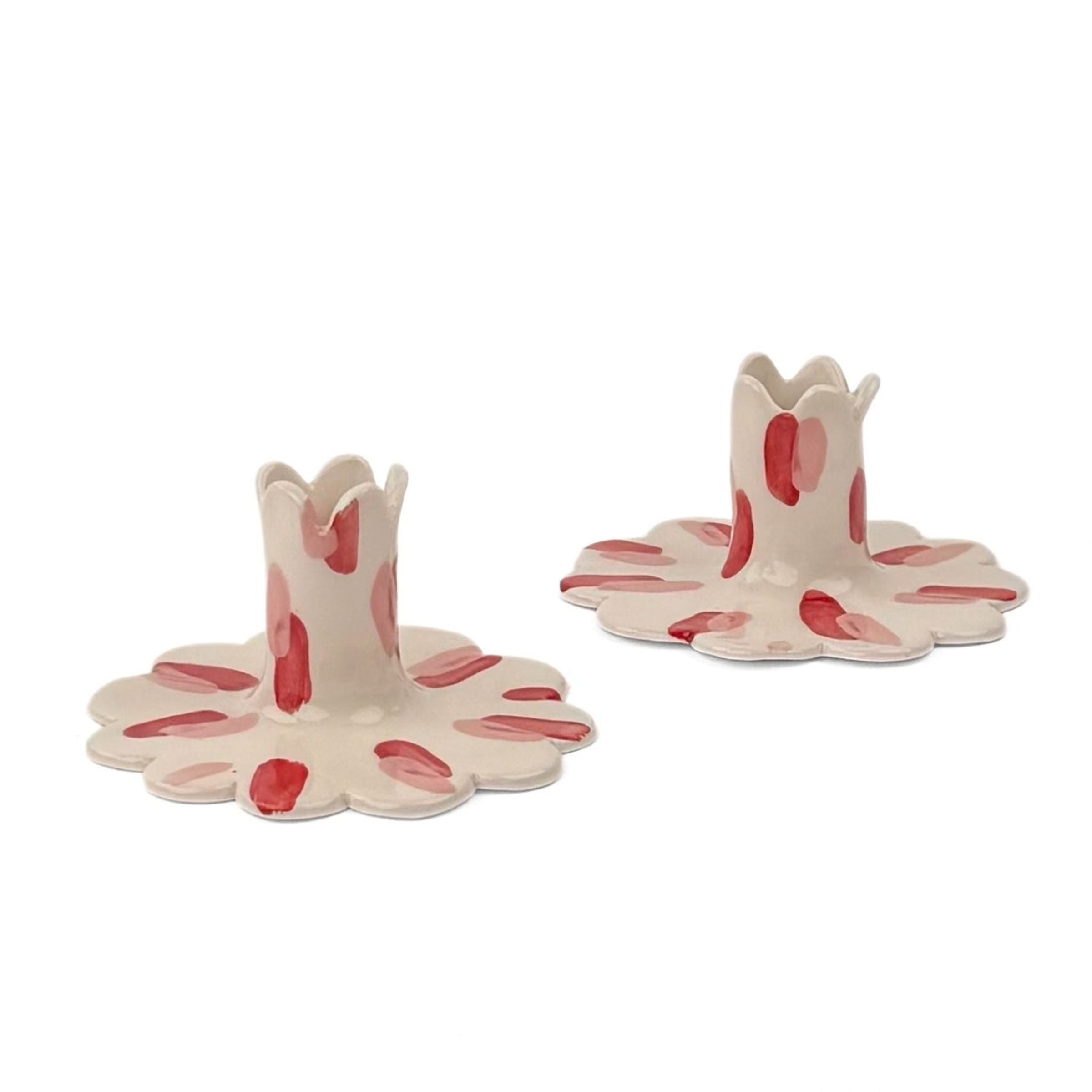 Pair of red and white ceramic petal-shaped candle holders with hand-painted red accents, designed for decorative tabletop display.
