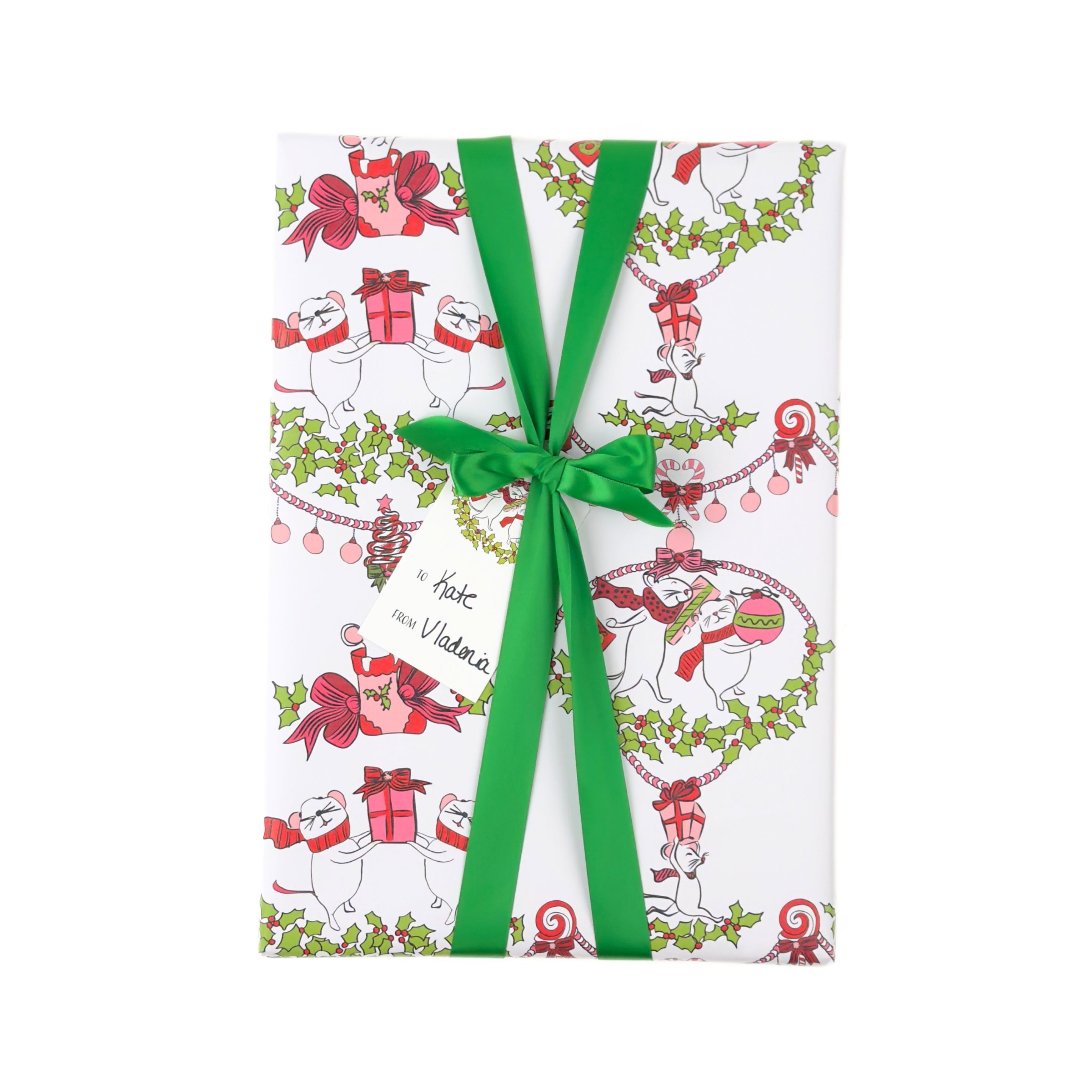 A wrapped gift box featuring holiday wrapping paper with a festive Christmas mouse pattern, tied with a bright green ribbon and bow. The paper is decorated with illustrations of white mice wearing red scarves and holding red gift boxes, surrounded by green holly and wreath motifs.