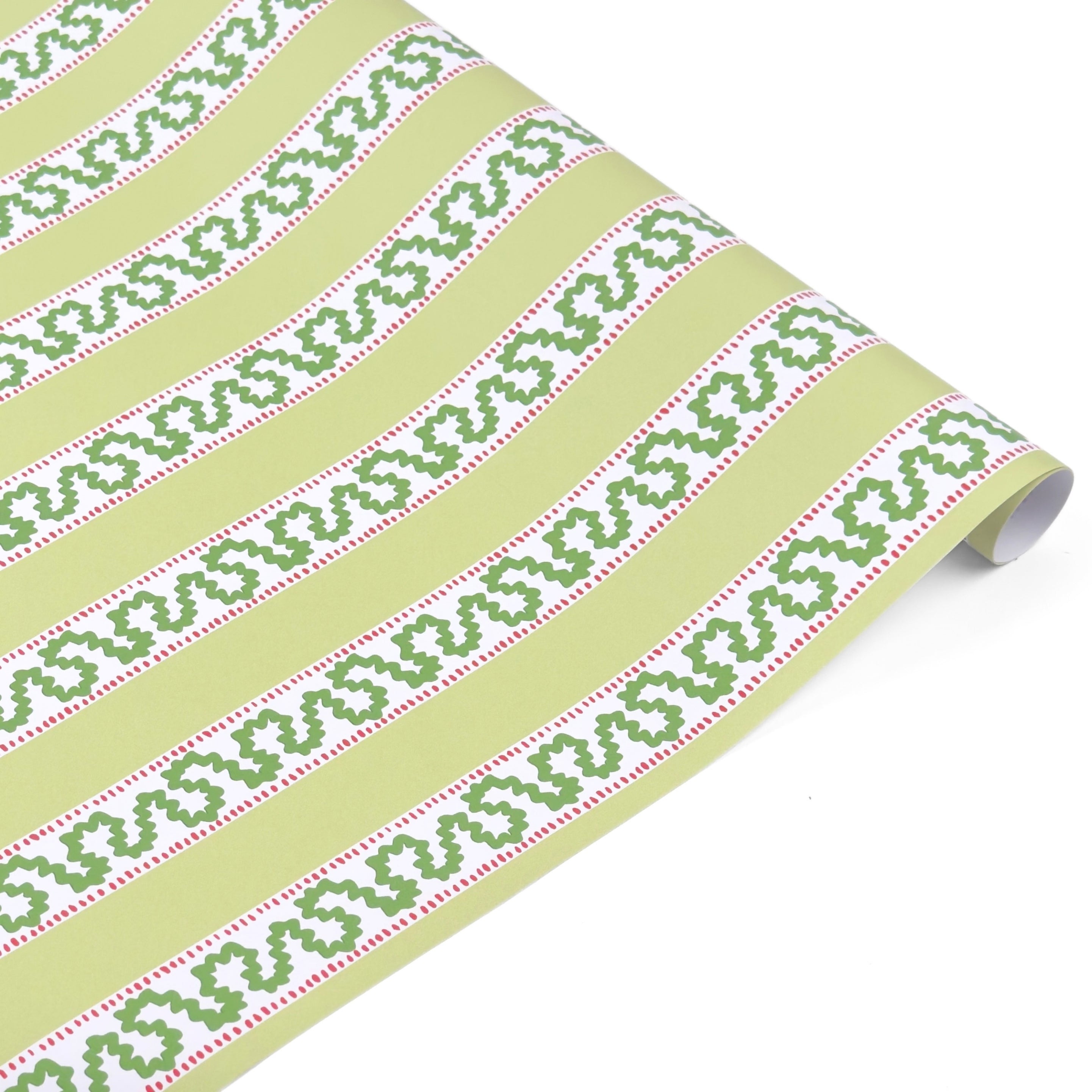 Light green Christmas wrapping paper roll with red and green holly-inspired stripe pattern, partially unrolled on a white surface.
