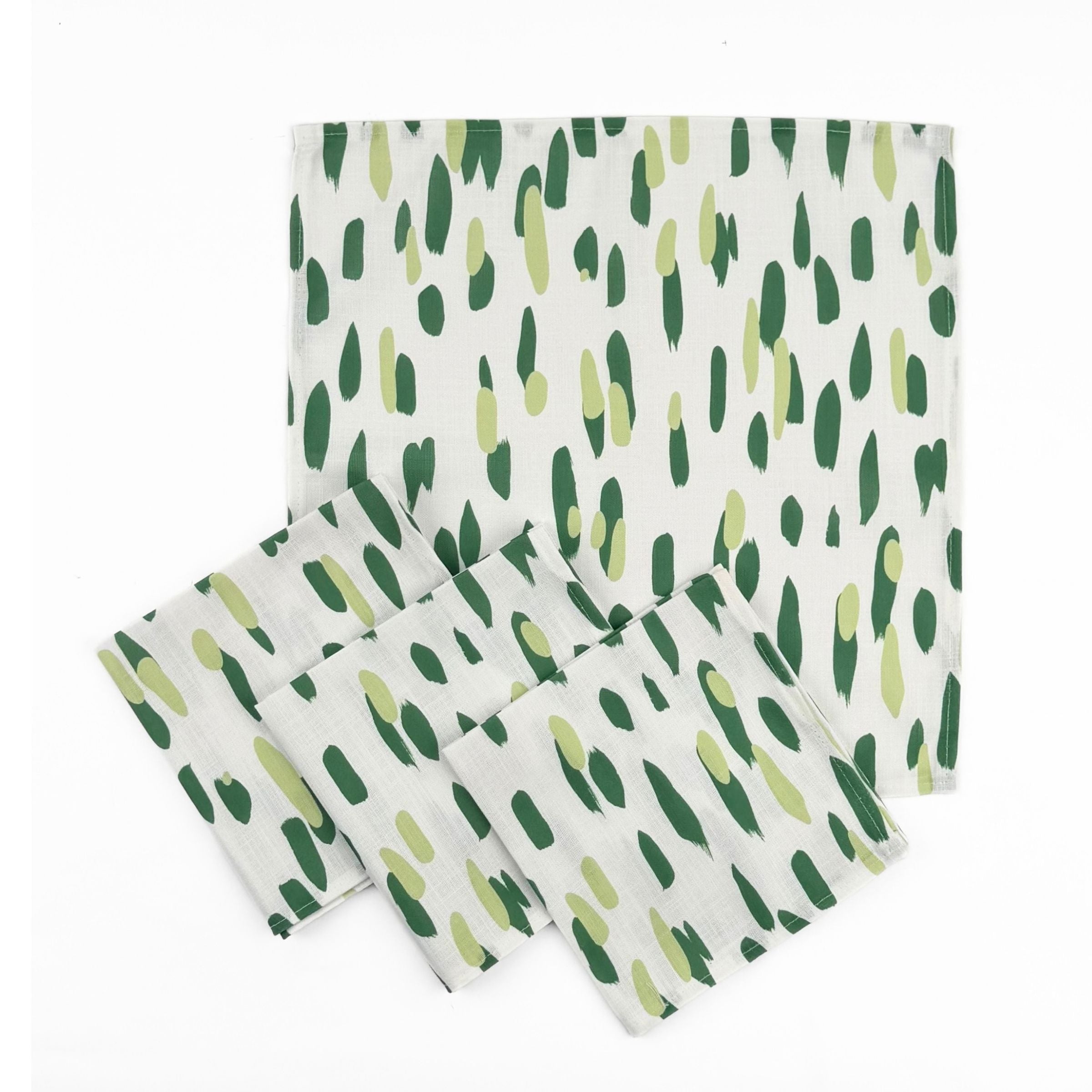 Set of White cloth dinner napkins featuring abstract green brushstroke patterns in varying shades for stylish tablescapes.