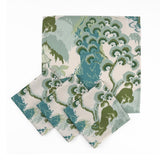 Set of Elegant cloth dinner napkins featuring traditional chinoiserie landscapes in soft green, blue, and ivory tones.