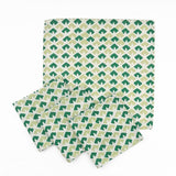 Set of White cloth dinner napkins featuring geometric green triangle patterns in two shades for stylish tablescapes.