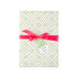 a present wrapped in light green bamboo lattice design gift wrap with a pink bow on a white background. 