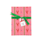 a present wrapped pink gift wrap with lobster, blue bow and green squiddly line motifs and a green bow