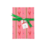 a present wrapped pink gift wrap with lobster, blue bow and green squiddly line motifs and a green bow