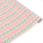 Pink and green striped Christmas wrapping paper roll with decorative pattern.