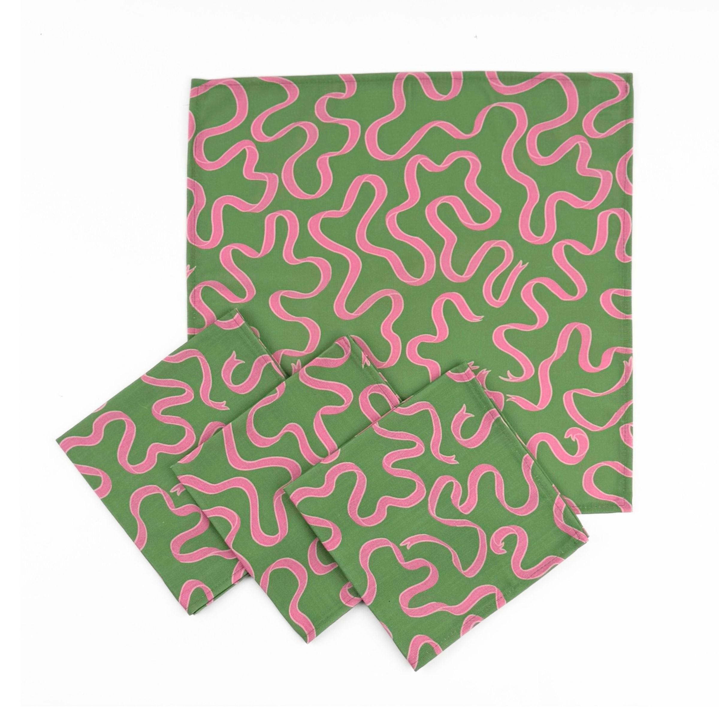 Set of Green cloth dinner napkins featuring playful pink swirling ribbon patterns, perfect for colorful table settings.