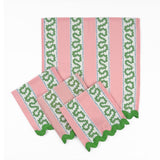 Set of Pink cloth dinner napkins featuring green wavy stripes, blue dotted accents, and green scalloped trim.