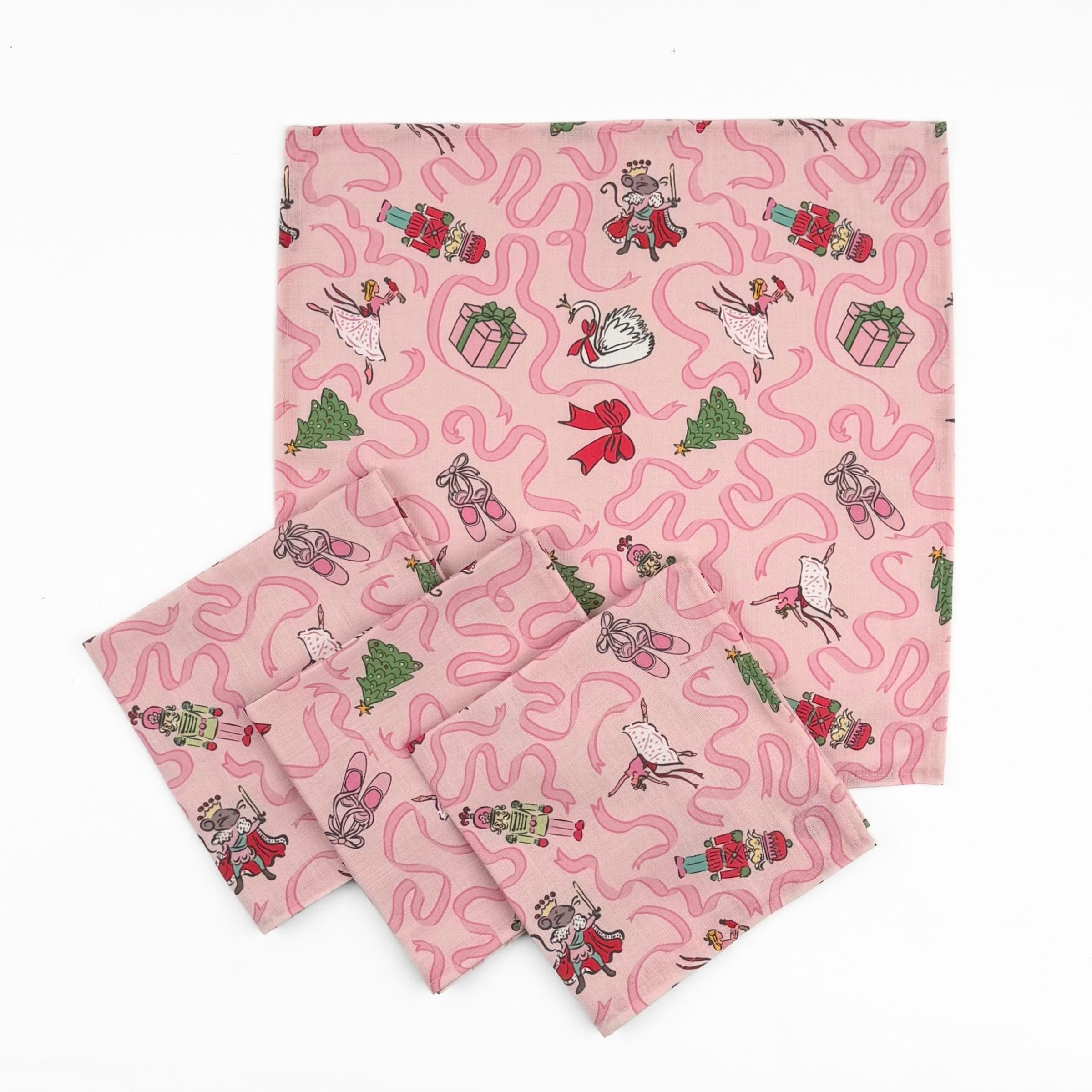 Set of Pink Christmas dinner napkins featuring swirling ribbons, nutcrackers, ballerinas, festive gifts, and whimsical holiday illustrations.