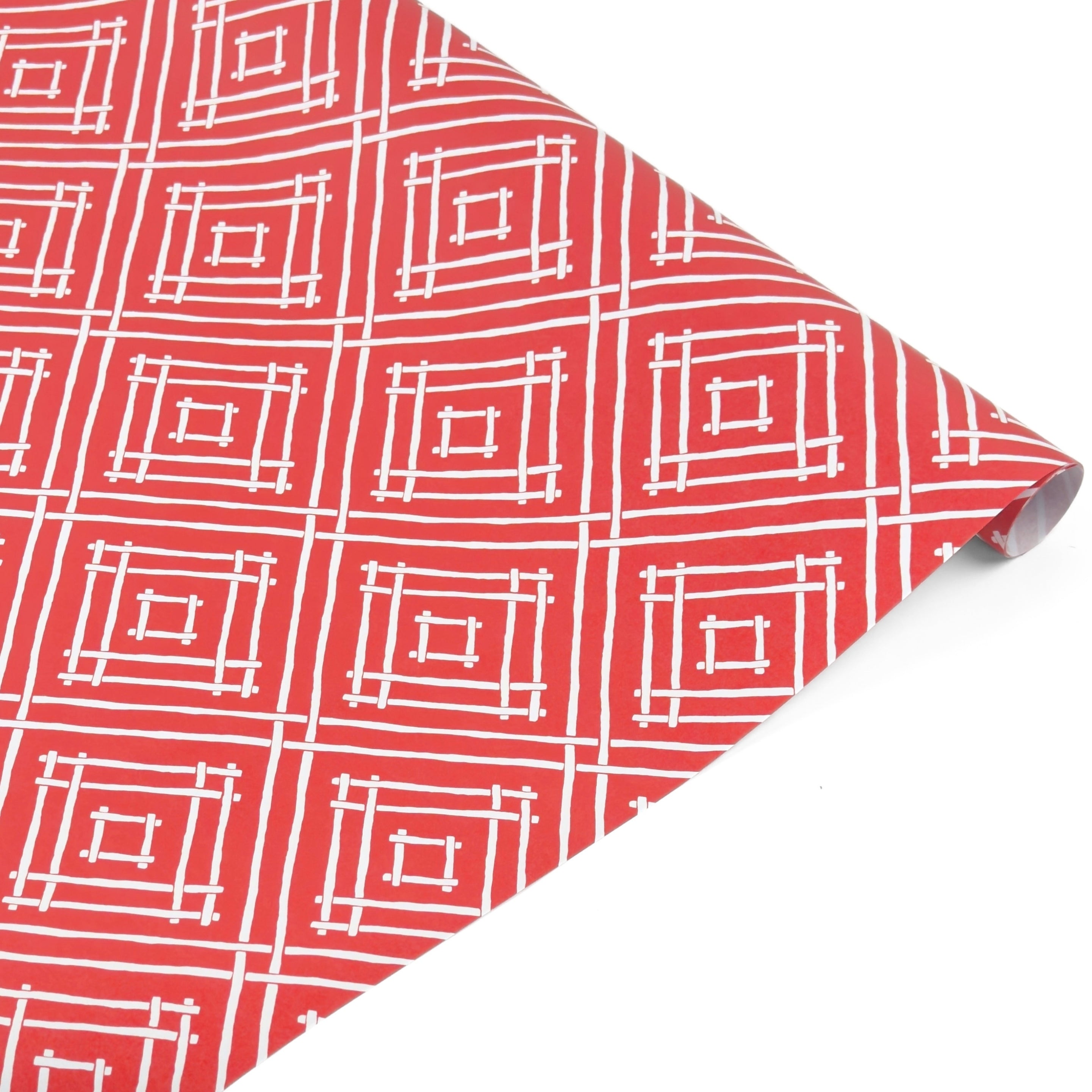 Rolled red gift wrap featuring white geometric square pattern.