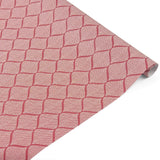 Rolled elegant gift wrapping paper featuring intricate red and white block print trellis patterns for beautiful presents.