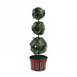 A tole metal three tiered holly topiary ball centerpiece with a striped red and green pot forming the base. 