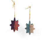 Hand-painted wooden patriotic star ornaments featuring red, white, and blue designs with decorative gold hanging cords.