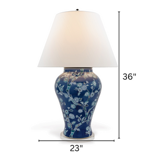 A blue and white table lamp featuring a blue and white chinoiserie lamp base and a white lampshade with arrow denoting dimensions 36" high and 23" wide