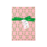 Elegant gift wrapping paper featuring intricate green bamboo lattice patterns on a soft pink background.