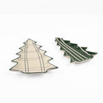 Two Christmas tree-shaped ceramic dishes on a white background, one with a cream and green plaid pattern and the other with a dark green and cream stripe pattern.