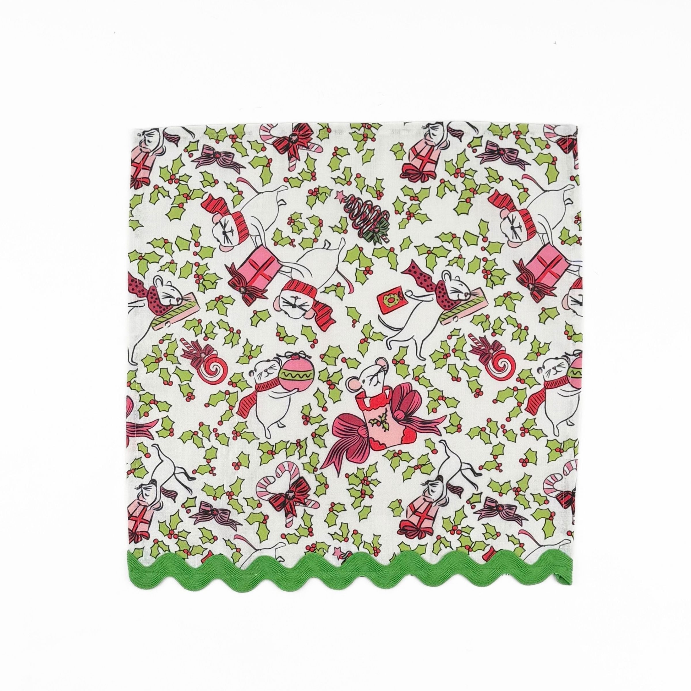 White Christmas dinner napkins featuring festive mice, holly leaves, colorful gifts, and green scalloped trim.