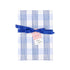 a gift wrapped in blue gingham Christmas paper with blue ribbon and holiday tag.