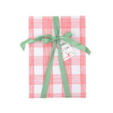 Gift wrapped in pink and white gingham paper with green ribbon and Christmas gift tag.