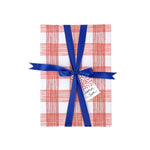 Gift wrapped in red and white gingham paper with blue ribbon and Christmas gift tag.