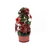 A large metal handpainted Christmas candle holder featuring red poinsettia flowers and green holly leaves with a pink base. 