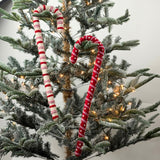 Large felt Christmas candy canes featuring festive red, pink, and cream stripes with playful patterns.
