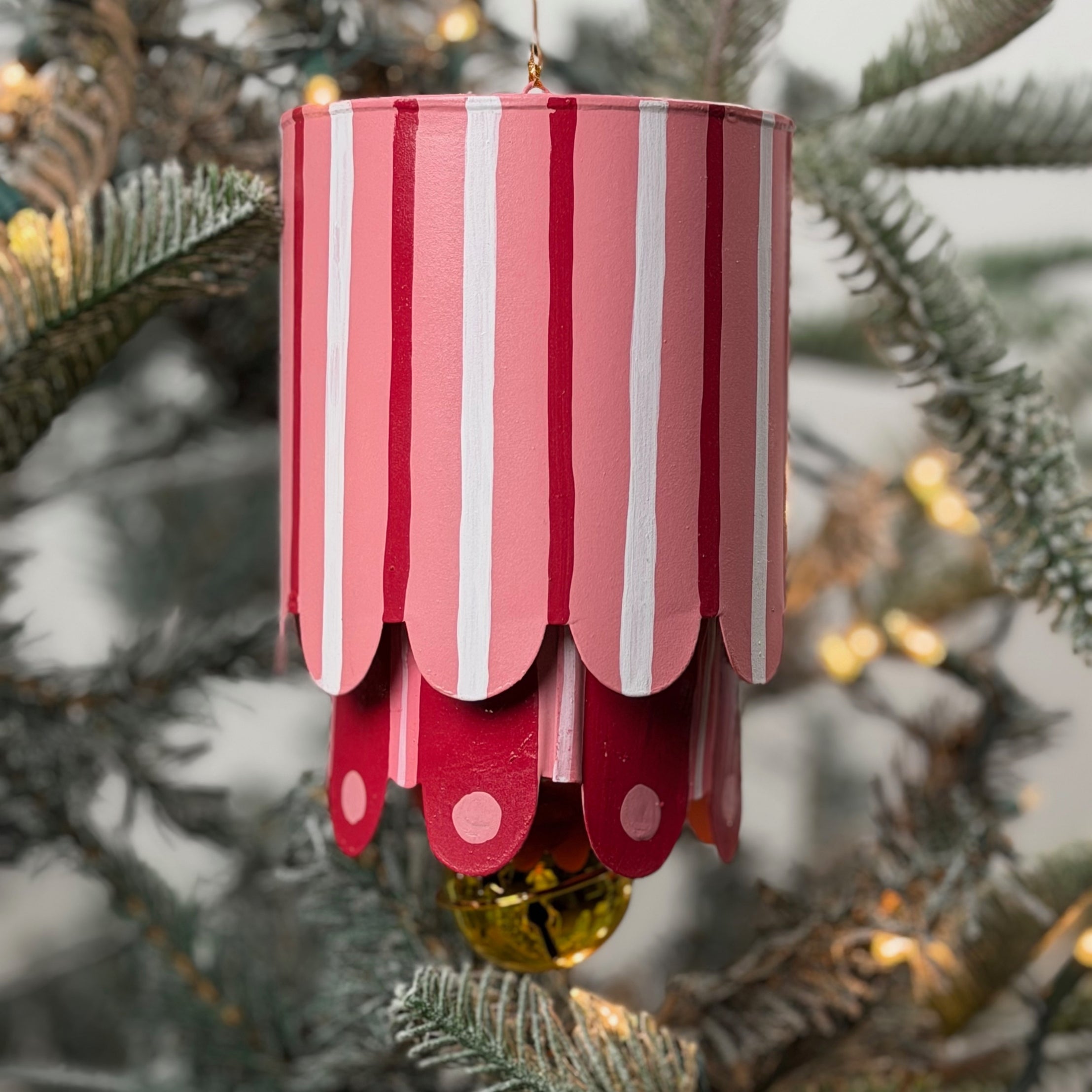 Colorful tole metal lantern Christmas ornaments featuring pink, and stripes with gold bell.