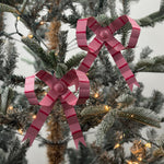 Small pink bow Christmas ornaments featuring red stripes and delicate ribbon loops for festive decorating.