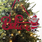 Decorative red christmas sign with 'Believe' text and a Santa Claus figure on christmas tree background