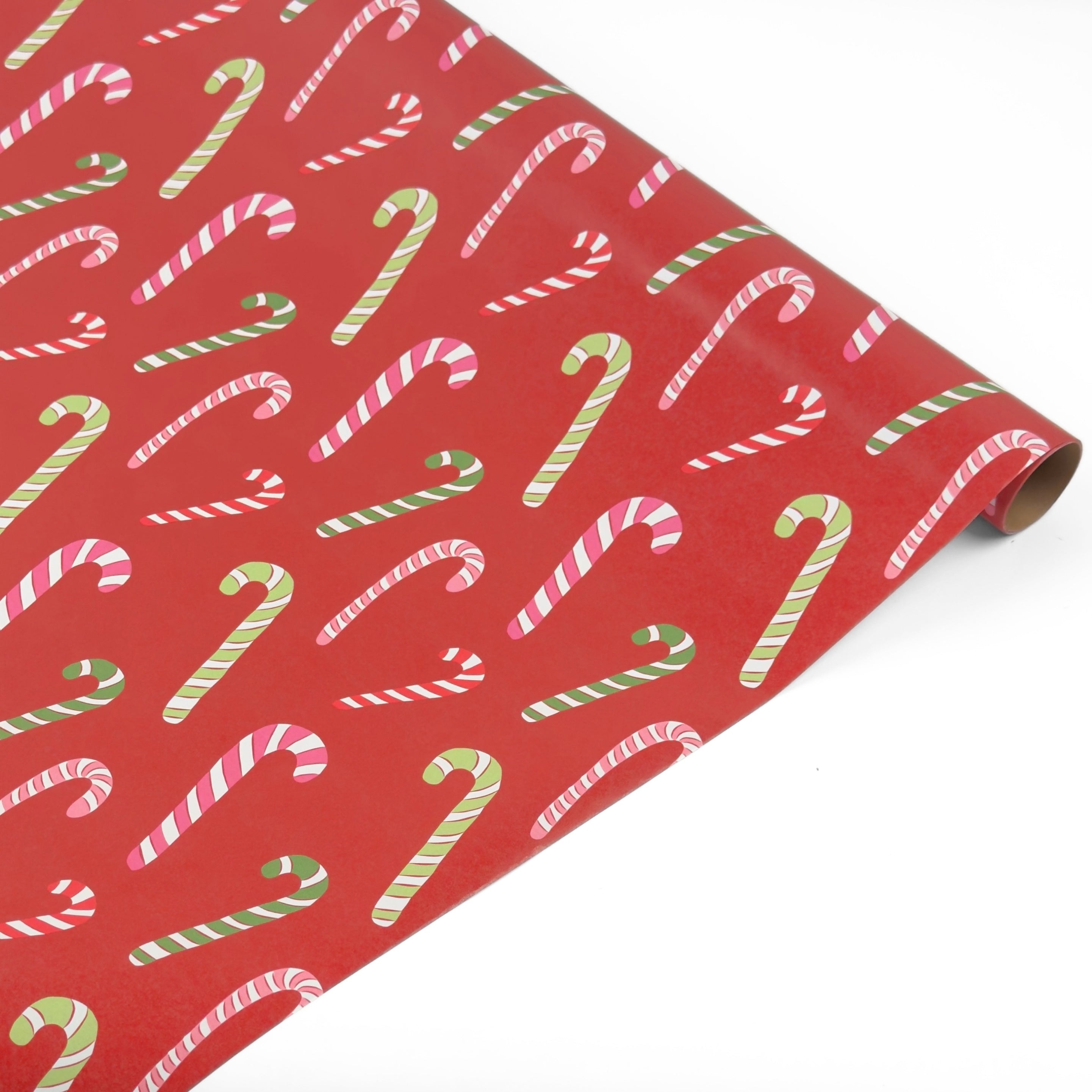 Red christmas wrapping paper with a repeating candy cane pattern, shown partially rolled on a white background.
