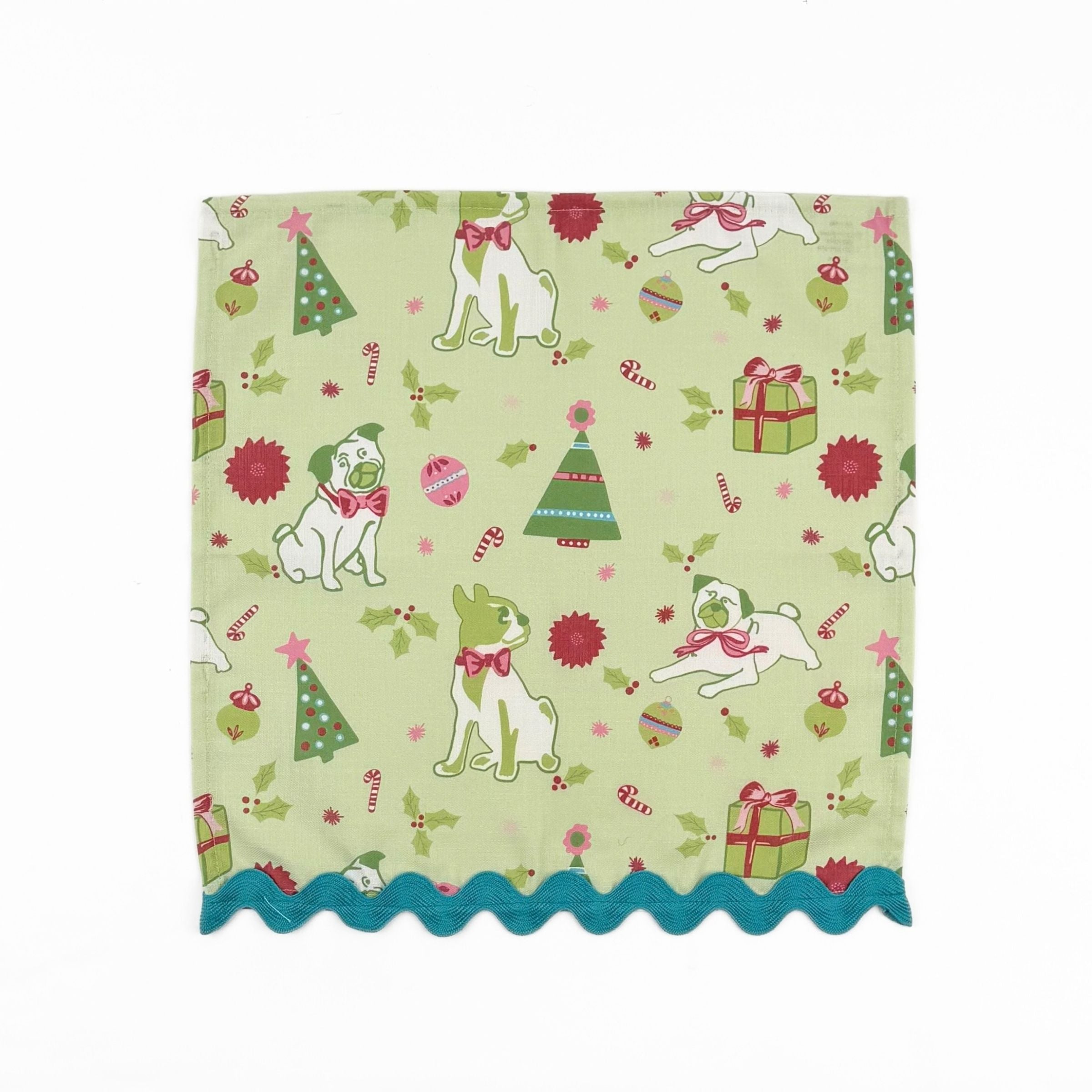Light green Christmas dinner napkins featuring festive pugs, holiday decorations, and bright turquoise ric rac trim.