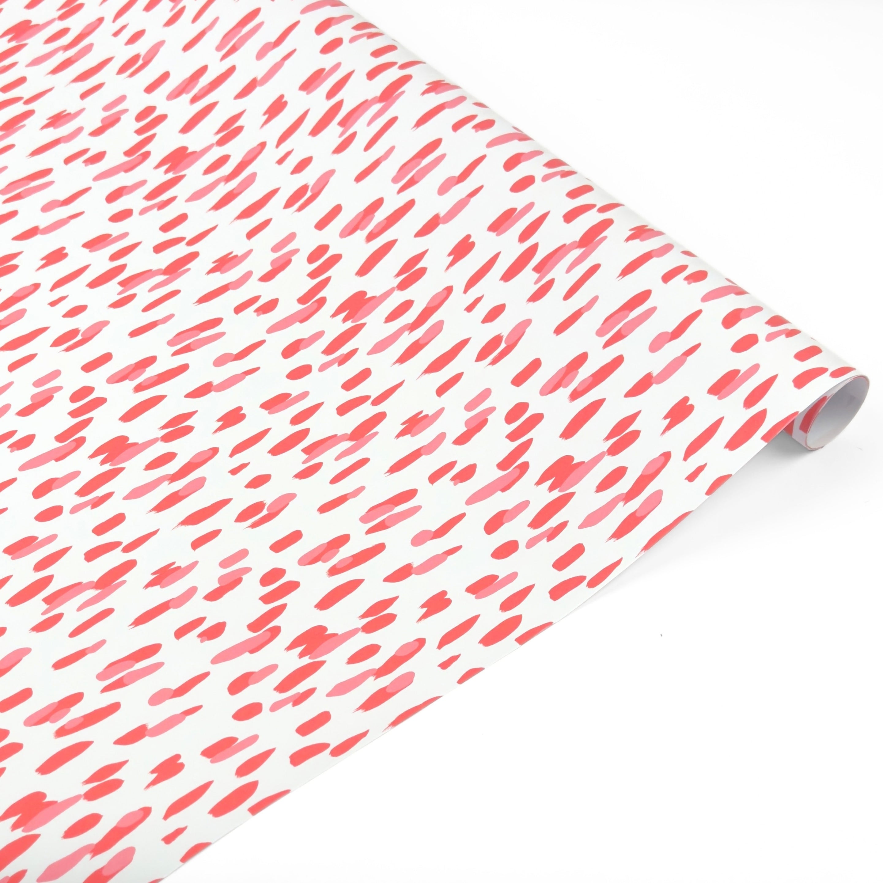 a roll of gift wrap with a pink brushstroke pattern design. 