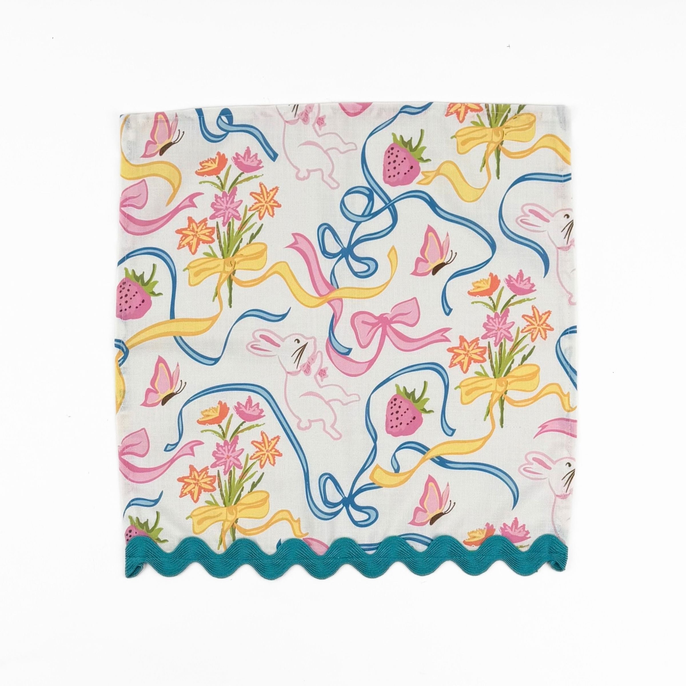 White dinner napkins featuring playful bunnies, colorful bows, strawberries, flowers, and turquoise ric rac trim.