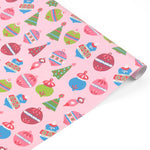 A roll of pink holiday wrapping paper featuring a colorful Christmas ornament pattern, shown on a clean white background.